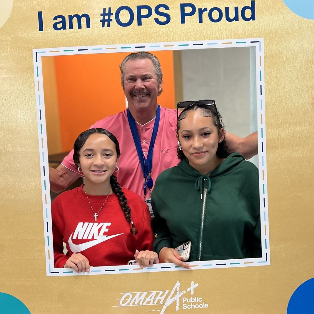  Students and a teacher pose with an #OPS Proud banner